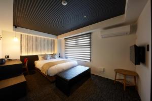 a bedroom with a bed and a desk and a television at Rinn Kamiebisu in Kyoto