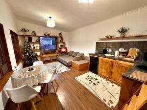 a living room with a table and a christmas tree at Eywa House in Kamenskoye Plato
