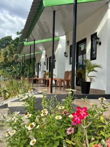 a garden with flowers in front of a building at JE Garden Guesthouse in Oecusse RAEOA in Deli