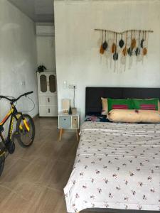 a bedroom with a bed and a bike in it at JE Garden Guesthouse in Oecusse RAEOA in Deli +7 photos