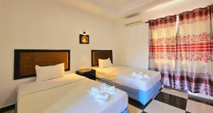 a hotel room with two beds and a window at B Guesthouse in Kampot