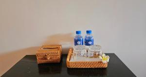 two bottles of water and glasses on a table at B Guesthouse in Kampot