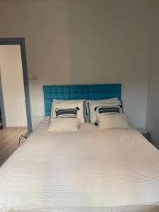 a large bed with a blue headboard and pillows at "Chez Maria" in Stroumbi