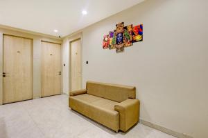 a couch in a room with a painting on the wall at Townhouse Oak Ram Lala Mandir Kanpur Formerly Hotel Sun Rise in Kaliānpur +36 photos