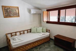 a small bed in a room with a window at Villa summertime walking distance from the sea with garden in Fregene