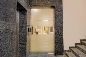 a glass door in a building with stairs at Townhouse Oak Ram Lala Mandir Kanpur Formerly Hotel Sun Rise in Kaliānpur