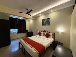 a bedroom with a bed and a ceiling fan at All Seasons Guest House I Rooms & Dorms in Madgaon