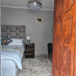 a bedroom with a bed and a wooden door at 14 Isabel Room 2 in Centurion