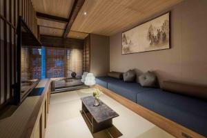 a living room with a blue couch and a table at Itose Machiya House in Kanazawa