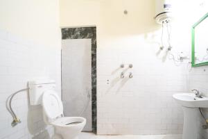 a white bathroom with a toilet and a sink at Timberwolves Vintage Manali in Manāli +19 photos