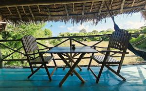 a table and two chairs on a porch at Kipepeo Beach and Village in Dar es Salaam