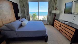 a bedroom with a bed and a television and the ocean at Nikki Beach Oceanfront Penthouse in Río Hato +19 photos
