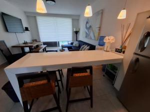 a kitchen and living room with a large white table at Nikki Beach Oceanfront Penthouse in Río Hato