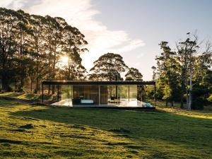 a glass house in the middle of a field at Triptych - The Glass House in Koonya