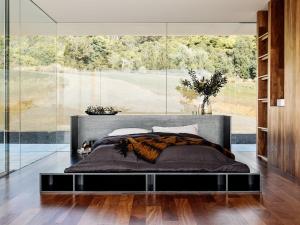 a bedroom with a large bed with a large window at Triptych - The Glass House in Koonya
