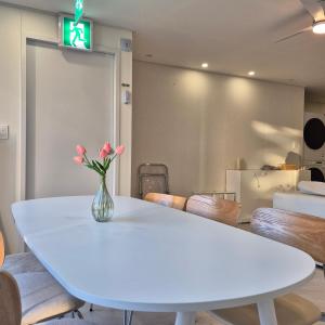 a white table with a vase of flowers on it at 포포스테이 in Busan +17 photos