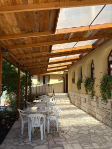 a patio with tables and chairs under a wooden roof at Family Hotel Chris in Sveti Vlas