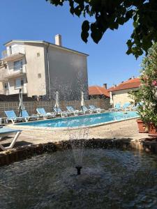 a fountain in the middle of a swimming pool at Family Hotel Chris in Sveti Vlas