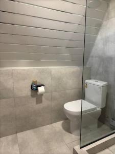 a bathroom with a toilet and a glass shower at Karapetyans Guest House in Stepʼanavan +7 photos