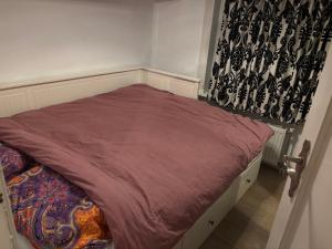 a small bed in a room with a curtain at Nice apartment next to the beach in Scheveningen +4 photos