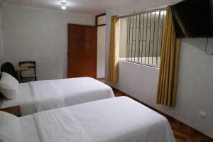 a hotel room with two beds and a window at El Sol de Nazca in Nazca