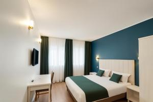 a hotel room with a bed and a blue wall at Thoiry Etoile Lodge, Sure Hotel Collection by Best Western in Thoiry