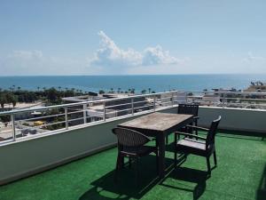 Ein Tisch und Stühle auf einem Balkon mit Blick auf das Meer in der Unterkunft WeNirvana Suit Hotel in Mezitli