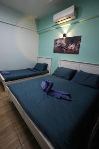 two beds in a room with blue walls at PortDickson Sakura 10Pax 3BR Glory Beach Resort Suite in Port Dickson +30 photos