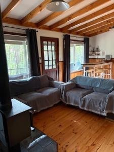 a living room with two couches and a kitchen at Balingup TimberTop Cottages in Balingup