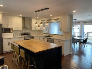 a kitchen with white cabinets and a wooden counter top at L'Anseau-Persil in Rivière-du-Loup