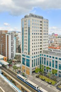 ein hohes weißes Gebäude mit einem Zug in einer Stadt in der Unterkunft Hotel UKETAMO in Taipeh