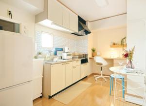 a kitchen with white cabinets and a table in it at Nagi Takamatsu 702 in Takamatsu