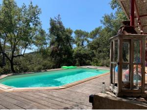 a swimming pool on a wooden deck with a lantern at Terre de Caliso in Carnoules
