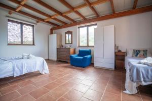 a bedroom with two beds and a blue chair at Appartamenti Quintavalle in Casa Marchetti