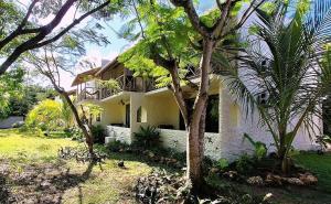 a white house with trees in front of it at Kipepeo Beach and Village in Dar es Salaam