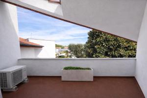 a balcony with a window and a tv and a plant at Villa summertime walking distance from the sea with garden in Fregene