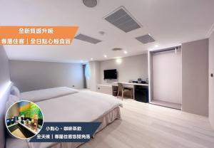 a bedroom with a bed and a desk with a computer at Nagahiro Hotel, Taichung Wenxin Branch in Taichung