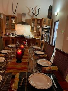 a table with plates and glasses on it in a kitchen at Luxury Villa at Elements Golf Course - Bela Bela in Warmbaths