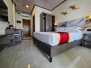 a bedroom with a large bed with a painting on the wall at Lagoon View Maldives in Bodufolhudhoo +67 photos