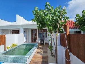 a villa with a swimming pool and a house at Lagoon View Maldives in Bodufolhudhoo