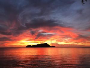 an island in the ocean with a sunset at San Nicolas Private Beach in Busuanga
