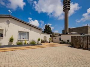 a building with a clock tower and a brick driveway at La Bella Vida Self Catering Apartments in Bellville
