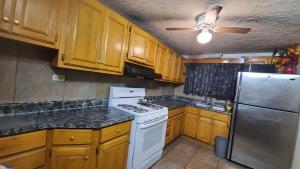 a kitchen with wooden cabinets and a white stove top oven at Casa Jardines in Mexicali +8 photos