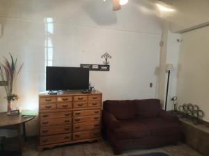 a living room with a couch and a television on a dresser at Casa Jardines in Mexicali