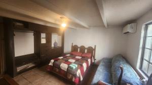 a small bedroom with a bed and a tv at Casa Jardines in Mexicali