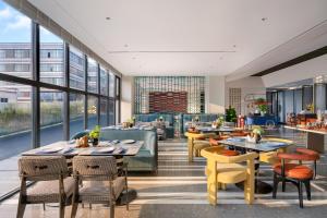 a restaurant with tables and chairs and windows at Novotel Yangquan High-Tech Zone in Yangquan