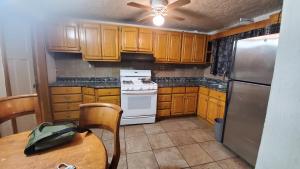 a kitchen with wooden cabinets and a table and a refrigerator at Casa Jardines in Mexicali