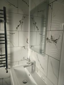 a white bathroom with a sink and a mirror at Byron View House in Luton