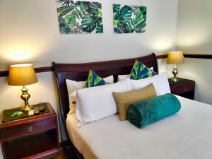 a bedroom with a white bed with two lamps at Park Living Guesthouse in Bloemfontein