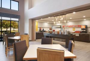 a restaurant with tables and chairs and a kitchen at Hampton Inn & Suites Cleveland-Mentor in Mentor